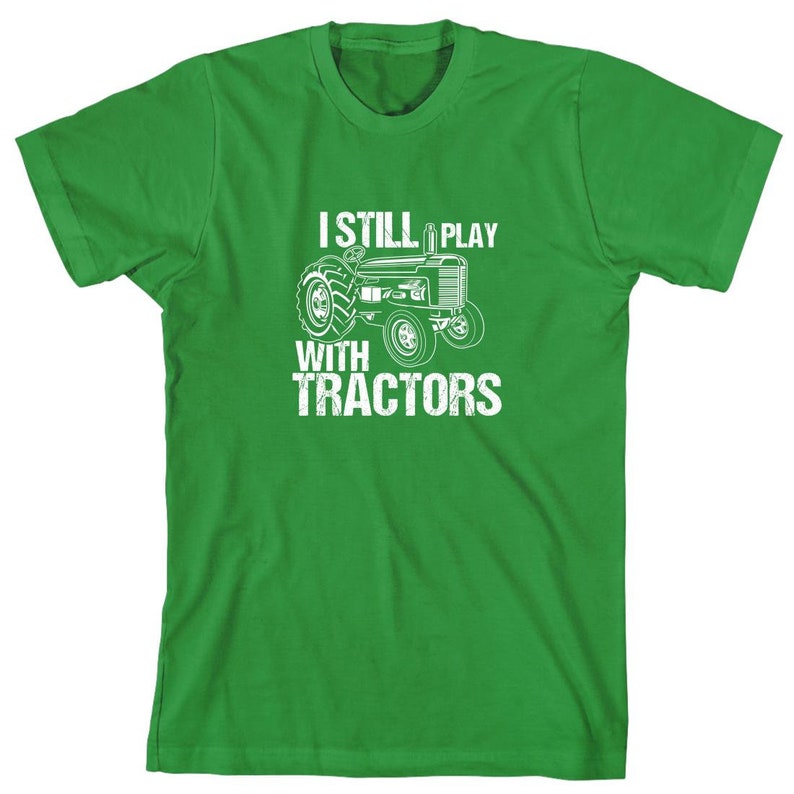 May include: Green t-shirt with a white tractor graphic and the text "I Still Play With Tractors".