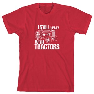May include: Red t-shirt with a white graphic of a tractor and the text "I Still Play With Tractors".