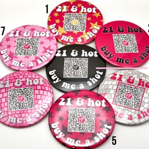 Puede incluir: Siete botones redondos de color rosa y blanco con un c&oacute;digo QR en blanco y negro y el texto "21 & hot buy me a shot" impreso en ellos. Los botones est&aacute;n numerados del 1 al 7.
