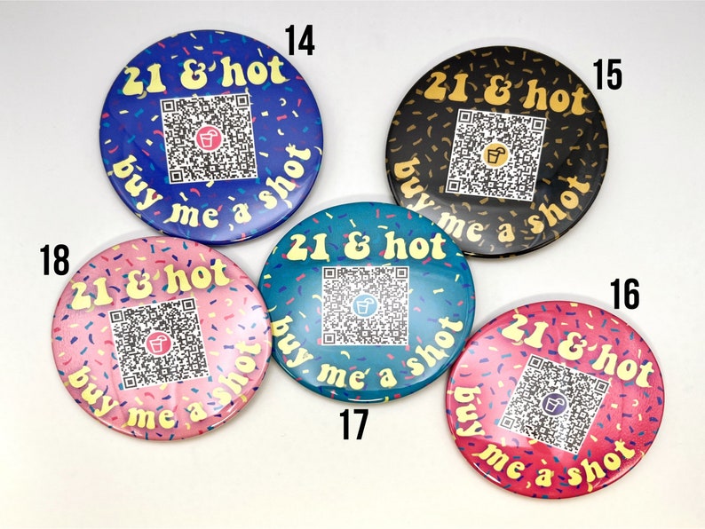 Puede incluir: Cinco botones redondos con un fondo de confeti colorido y el texto "21 & hot buy me a shot" en amarillo. Cada bot&oacute;n tiene un fondo de color diferente: azul, negro, azul verdoso, rosa y rosa. Cada bot&oacute;n tiene un c&oacute;digo QR en el centro.