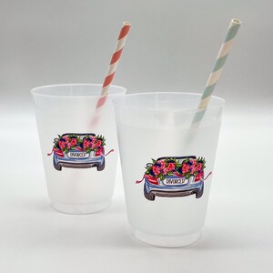 May include: Two frosted plastic cups with a car graphic on the front, decorated with flowers and the word "DIVORCED". Each cup has a striped paper straw. One straw is red and white, the other is green and white.