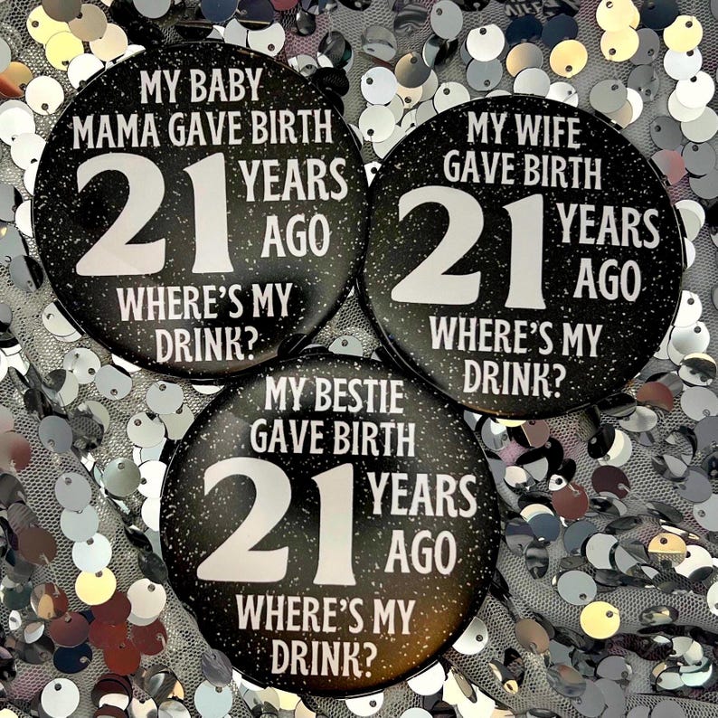 May include: Three black and white round buttons with glitter. Each button has the text "21 years ago" and "Where's my drink?" with a different phrase above the number. The phrases are "My baby mama gave birth", "My wife gave birth", and "My bestie gave birth".