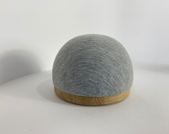 May include: A gray fabric dome with a wooden base. The fabric has a textured, woven appearance.