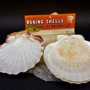 May include: Two natural baking shells with a package labelled "BAKING SHELLS". The shells are white with brown and red edges. The package is orange with black text and a shell illustration.