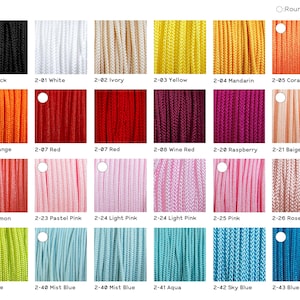 May include: A color chart displaying 2mm round cord in twenty-four distinct shades including black, white, ivory, yellow, mandarin, coral, orange, red, wine red, raspberry, beige peach, salmon, pastel pink, light pink, pink, rose pink, lime, and blue.