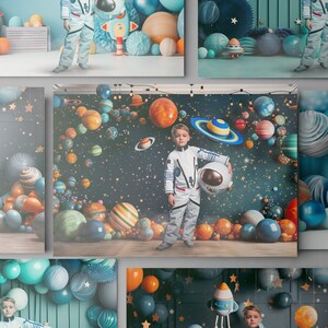 May include: A young child dressed in a white astronaut costume holds a white helmet with a black visor. The child is standing in front of a backdrop depicting a dark blue space scene with colorful planets and stars.