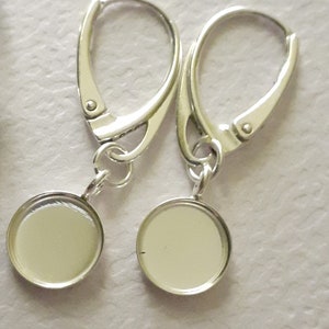 Peut inclure: Une paire de supports de boucles d'oreilles en argent avec des bélières rondes, plates et argentées. Les bélières mesurent environ 2,5 cm de diamètre.