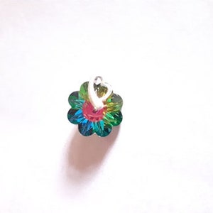 K&ouml;nnte beinhalten: Ein kleiner, mehrfarbiger Blumenanh&auml;nger mit einem silbernen Herzanh&auml;nger. Die Blume ist aus schimmerndem Glas und hat eine rote Mitte.