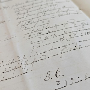 Könnte beinhalten: Eine Nahaufnahme einer handgeschriebenen Seite aus einem Tagebuch oder einem Kassenbuch. Die Seite ist mit schwarzer Tinte gefüllt und enthält Zahlen, Daten und andere handschriftliche Texte. Der Text ist schwer zu lesen, aber es scheint sich um eine Aufzeichnung von Finanztransaktionen zu handeln.