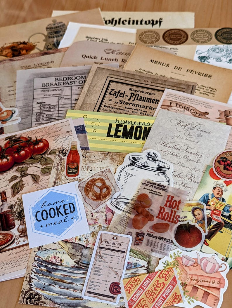 May include: A collection of vintage paper ephemera with a variety of designs and text, including a menu, a recipe, and a sign for homemade lemonade. The papers are arranged on a wooden surface and include images of food, drinks, and other objects.