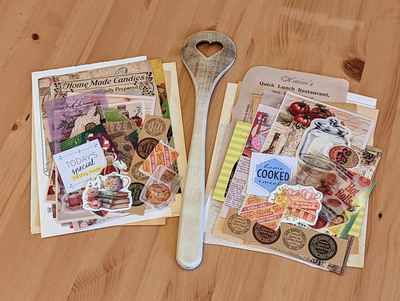 May include: Two stacks of vintage paper ephemera with a wooden spoon. The top stack includes a variety of paper scraps, including a sticker that says "Home Made Candies" and another sticker that says "Today's Special Freshly Made". The bottom stack includes a variety of paper scraps, including a sticker that says "Kaim's Quick Lunch Restaurant" and another sticker that says "Home Cooked Meal".
