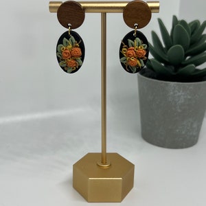 Black oval with orange and yellow florals on wood hardware | polymer clay earrings