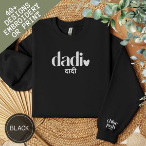 Könnte beinhalten: Schwarzes Sweatshirt mit dem Wort "dadi" in Weiß und einem Herzsymbol. Das Wort "dadi" ist auch auf Hindi geschrieben. Der Ärmel trägt den Text "chloe josh xoxo". In der oberen linken Ecke steht der Text "40+ DESIGNS STICKEREI ODER DRUCK".