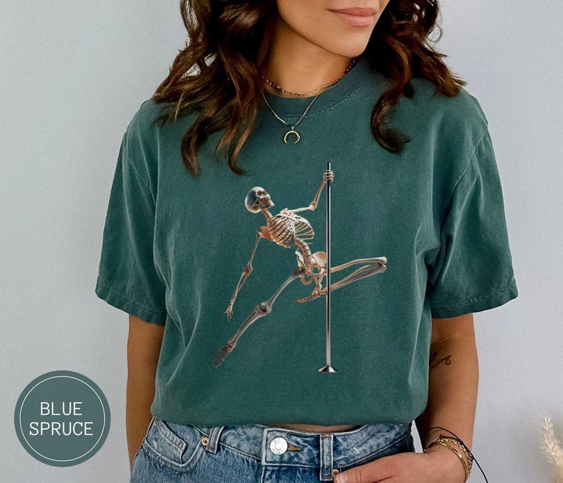 May include: A blue spruce t-shirt features a skeleton figure pole dancing. The graphic is in a realistic style. The shirt is a solid color and has a relaxed fit. The text "BLUE SPRUCE" is in a circle on the bottom left.