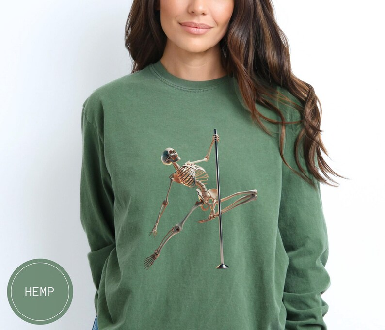 May include: Green long-sleeve sweatshirt featuring a skeleton figure pole dancing. The skeleton is in a dynamic pose, with arms and legs extended. The word "HEMP" is printed on a green circle in the lower left corner.