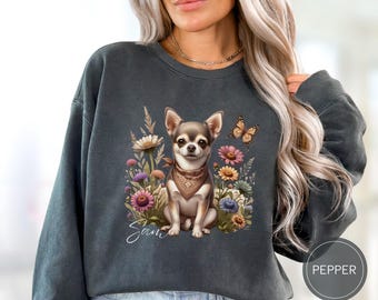 May include: A dark gray sweatshirt with a floral design featuring a chihuahua wearing a bandana. The text "Sam" is printed on the sweatshirt.