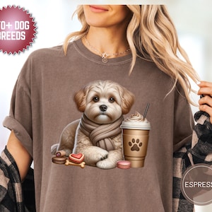 Op de afbeelding: Bruin T-shirt met een afbeelding van een hond met een sjaal, samen met een koffiekopje, macarons en een bot. Het shirt toont de tekst "170+ DOG BREEDS" in een rode cirkel en "ESPRESSO" in een bruine cirkel.