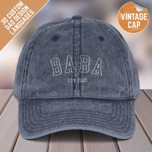 Puede incluir: Una gorra de béisbol de mezclilla azul con la palabra "BABA" bordada en blanco con el texto "EST 2025" debajo.