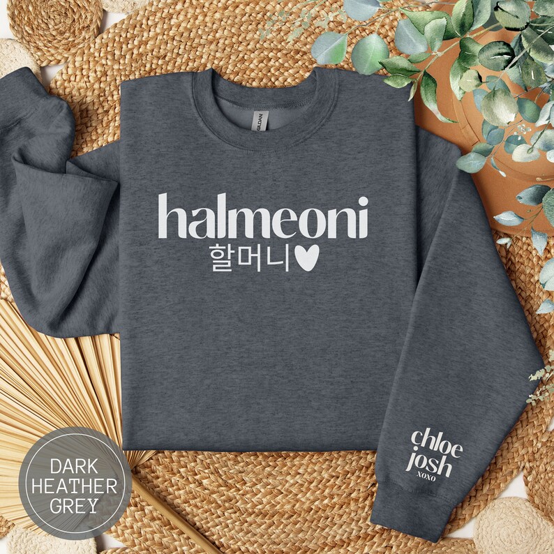 May include: Dark heather grey sweatshirt with the text "halmeoni 할머니" and a heart in white. The left sleeve has the text "chloe josh" in white.