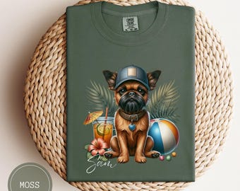 May include: A green t-shirt with a cartoon image of a Brussels Griffon dog wearing a hat and sunglasses, holding a cocktail and a beach ball. The text "Sam" is written below the dog.