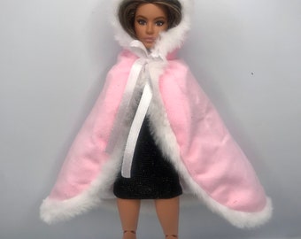 Capa con capucha de color rosa para muñecas. Mantón de muñecas con ribete de pelo.