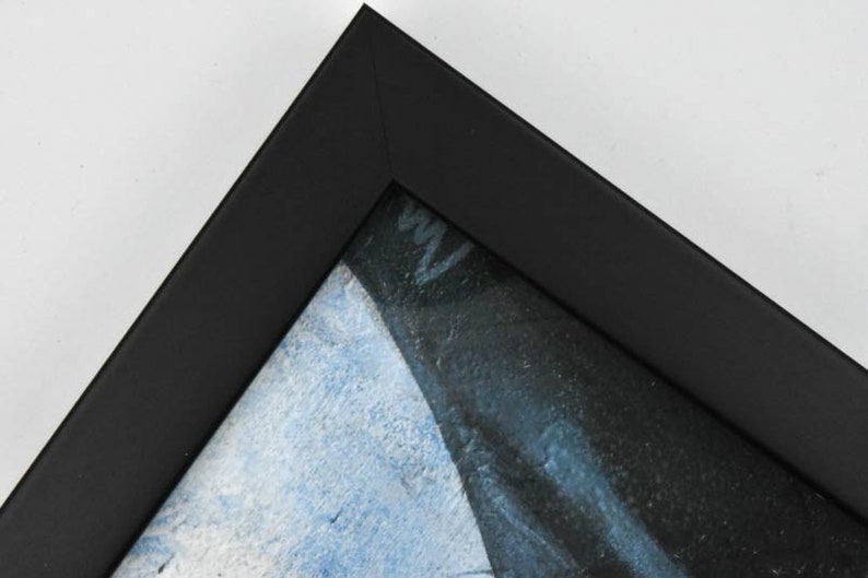 May include: Close-up of a black picture frame with a blue and white painting inside.