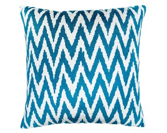 May include: A blue and white patterned throw pillow with a chevron design. The pillow is made of a soft, plush fabric.