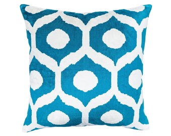 May include: A turquoise blue throw pillow with a white geometric pattern. The pattern is made up of repeating circles and ovals.