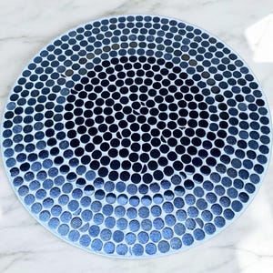 May include: A round blue and white table mat with a pattern of small circles.