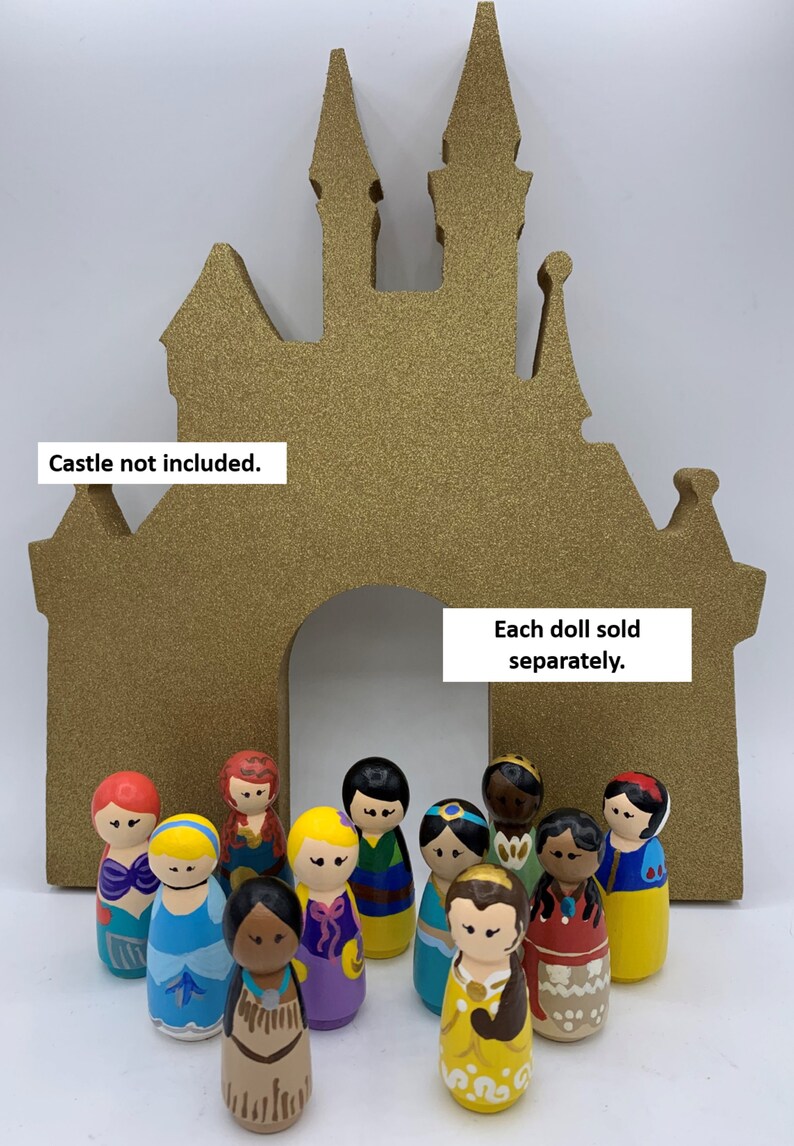 May include: A collection of 12 hand-painted wooden dolls, each depicting a different Disney princess, standing in front of a gold glitter castle cutout. Each doll sold separately. Castle not included.