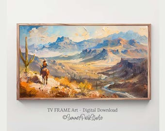 May include: A framed landscape painting depicts a cowboy on horseback traversing a desert canyon. The artwork features a palette of blues, oranges, and browns, with a river winding through the valley. The painting is labeled "TV FRAME Art - Digital Download."