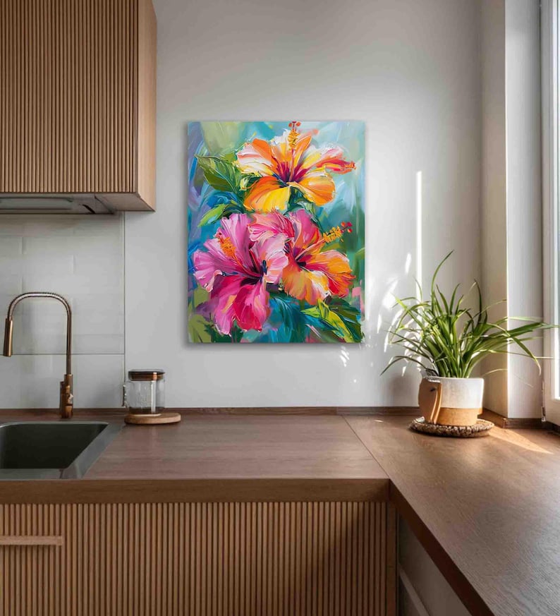 May include: A vibrant floral painting featuring two hibiscus flowers in shades of pink, orange, and yellow. The artwork showcases a close-up view of the blossoms with green leaves against a blue and green background. The painting is displayed on a white wall.