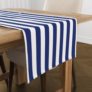 Puede incluir: Un camino de mesa a rayas blancas y azul marino sobre una mesa de madera. El camino de mesa mide aproximadamente 35 cm de ancho y 178 cm de largo.
