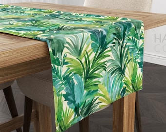Puede incluir: Un camino de mesa con estampado de hojas tropicales verdes y blancas sobre una mesa de madera. El camino de mesa mide 35,5 cm de ancho y 177,8 cm de largo. El camino de mesa está hecho de 100% algodón y es lavable a máquina.