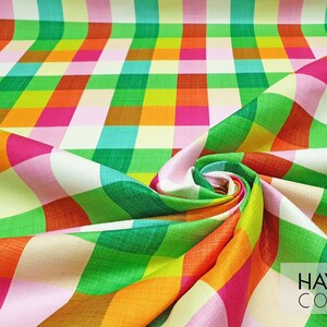 May include: A colorful fabric with a checkered pattern in shades of pink, green, orange, and yellow. The fabric is folded and twisted, creating a swirling effect. The text "HAVANA CONCEPT" is visible in the bottom right corner.