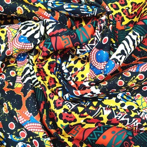 Pu&ograve; includere: Tessuto colorato con un design a stampa geometrica e animale. Il tessuto presenta una miscela di colori rosso, giallo, blu, nero e bianco.