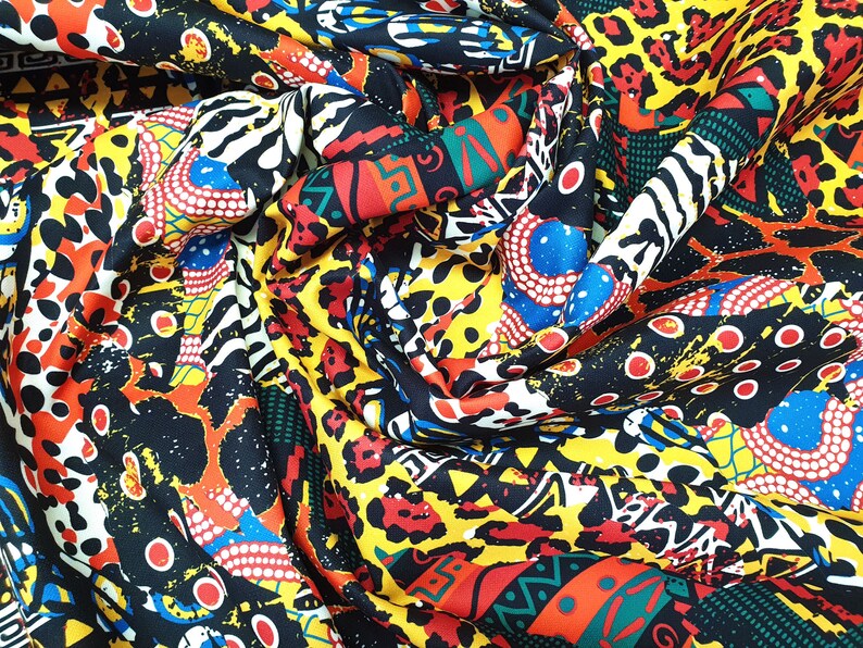 Pu&ograve; includere: Tessuto colorato con un design a stampa geometrica e animale. Il tessuto presenta una miscela di colori rosso, giallo, blu, nero e bianco.
