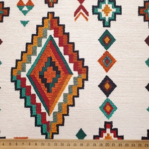 May include: White fabric with a repeating geometric pattern in shades of orange, red, green, and black. The pattern features a large diamond shape in the centre of the fabric.