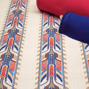 May include: White fabric with vertical stripes of blue, red, and gold geometric patterns. The fabric is shown with a red and a blue fabric swatch.