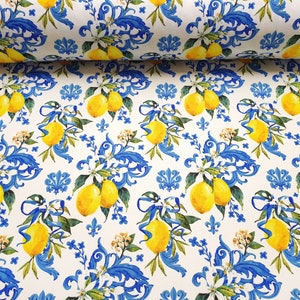 May include: White fabric with a repeating pattern of blue and yellow lemons, white flowers, and blue floral designs.