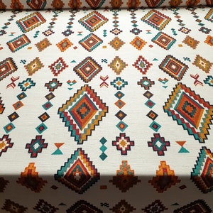 May include: White fabric with a repeating geometric pattern in shades of orange, red, teal, and brown. The pattern features a series of diamonds and squares.