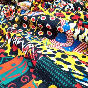 Pu&ograve; includere: Un tessuto colorato con una variet&agrave; di motivi, tra cui forme geometriche, stampe animalier e pois. Il tessuto &egrave; nero, giallo, rosso, blu, verde e bianco.