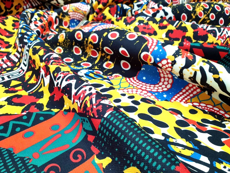 Pu&ograve; includere: Un tessuto colorato con una variet&agrave; di motivi, tra cui forme geometriche, stampe animalier e pois. Il tessuto &egrave; nero, giallo, rosso, blu, verde e bianco.