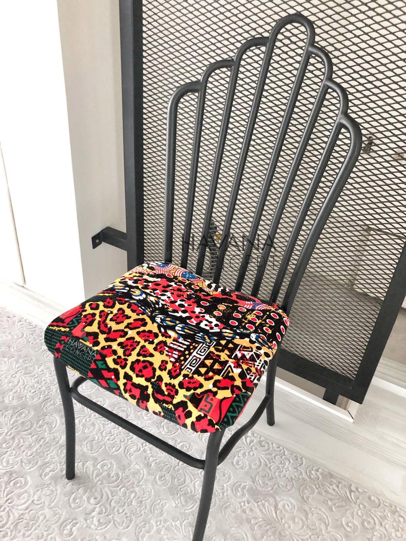 Pu&ograve; includere: Sedia in metallo nero con un cuscino di seduta a motivi colorati. Il cuscino presenta una stampa leopardata, forme geometriche e una variet&agrave; di colori, tra cui rosso, giallo e nero.