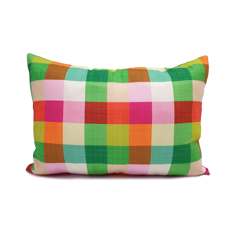 May include: A colorful pillow with a checkered pattern in shades of green, orange, pink, and red.