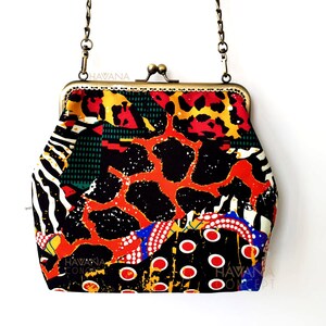 Pu&ograve; includere: Una pochette colorata con una tracolla a catena dorata. La pochette &egrave; realizzata in tessuto con sfondo nero e un motivo rosso, arancione, giallo, verde, bianco e blu. La pochette ha una chiusura a scatto e il testo "HAVANA" &egrave; stampato sul davanti.