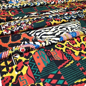 Pu&ograve; includere: Un tessuto colorato con un design a patchwork che presenta stampe animalier, motivi geometrici e forme astratte in tonalit&agrave; di rosso, giallo, nero, verde e bianco.