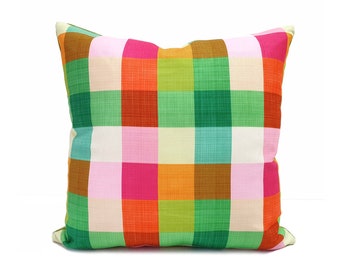 Puede incluir: Una almohada colorida con un patrón de cuadros en tonos de rosa, naranja, verde y marrón.