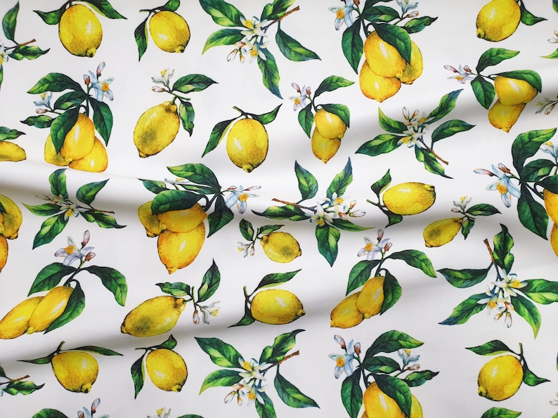 May include: White fabric with a repeating pattern of yellow lemons and green leaves. The lemons are drawn in a watercolor style and have a realistic appearance.