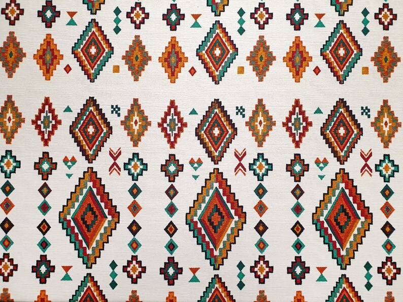 May include: White fabric with a repeating pattern of colourful geometric shapes. The pattern features a variety of diamond shapes in shades of orange, red, green, and blue. The background is white.